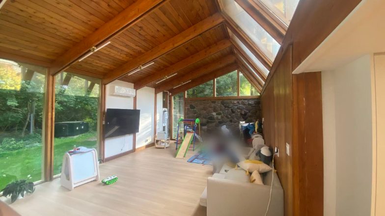 Sunroom with wood ceiling, glass walls and a wall-mounted TV before the build