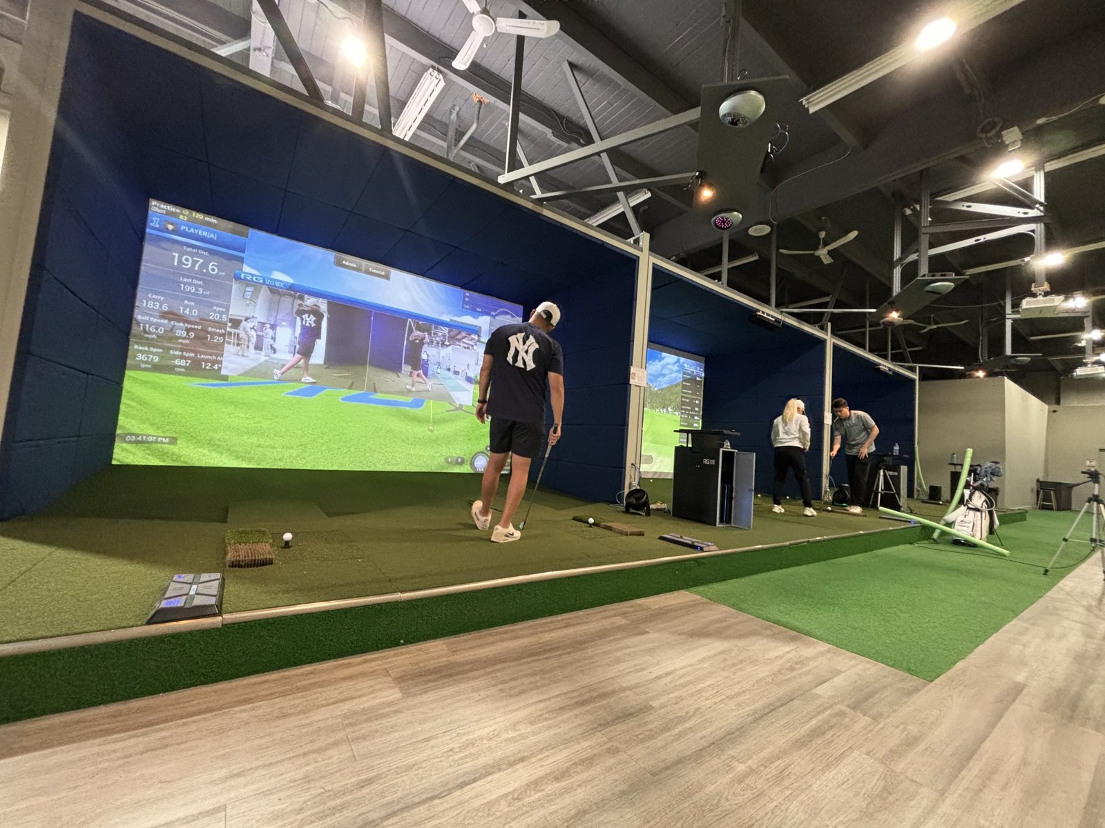 Golfers competing in RG Golf Simulator bays at Clubhouse Vancouver
